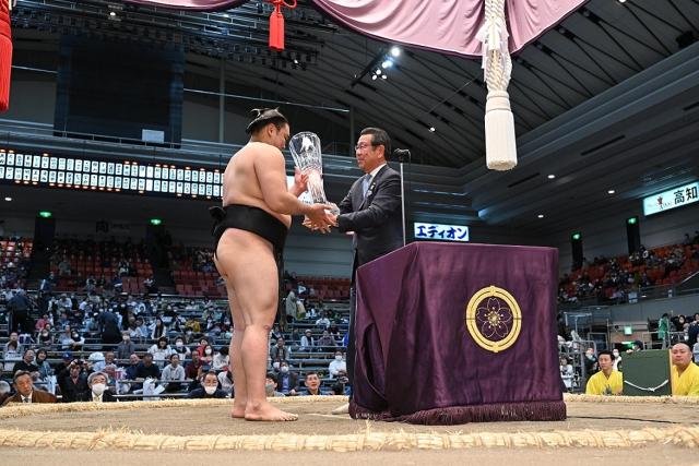 Mr. Kazumasa Kuzumura handovers the cup to Kiribayama. 