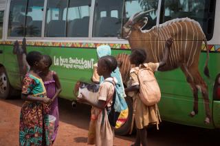 Toulavý autobus v městečku Messamena před zahájením své oficiální první jízdy. Zdobí ho nejen obrázky goril, ale například i bongů.